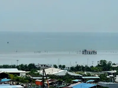 a large body of water with a pier in the distance at Seaview and 5mins to Paddy Field and Beach in Sekincan