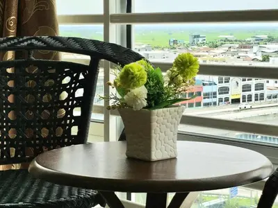 a vase with flowers sitting on a table in front of a window at 8\u697c\u6c11\u5bbf Enjoy the Paddy Field View in Sekincan