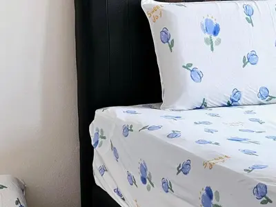 a bed with a pillow with blue flowers on it at 8\u697c\u6c11\u5bbf Enjoy the Paddy Field View in Sekincan