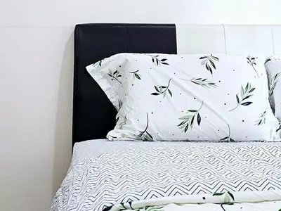 a bed with white pillows and green leaves on it at 8\u697c\u6c11\u5bbf Enjoy the Paddy Field View in Sekincan
