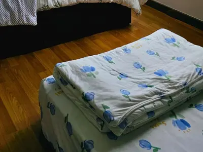 a mattress with blue flowers on it sitting on the floor at 8\u697c\u6c11\u5bbf Enjoy the Paddy Field View in Sekincan