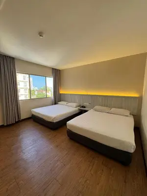 a hotel room with two beds and a window at Hotel Regal Malaysia in George Town