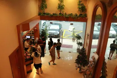a group of people standing in a room with a christmas tree at Hotel Regal Malaysia in George Town