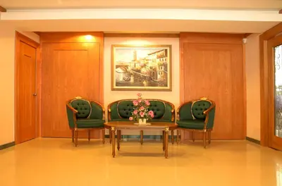 a waiting room with a table and green chairs at Hotel Regal Malaysia in George Town