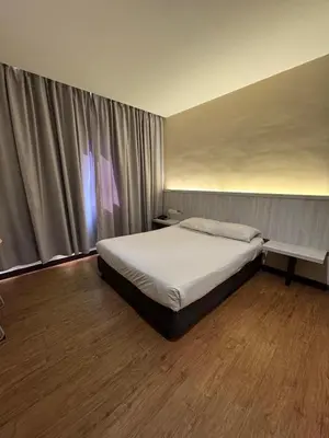 a bedroom with a white bed and a window at Hotel Regal Malaysia in George Town