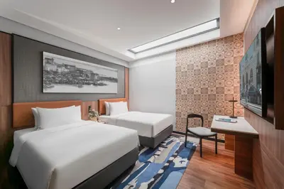 a hotel room with two beds and a television at Citadines Connect Bertam Georgetown Penang in George Town