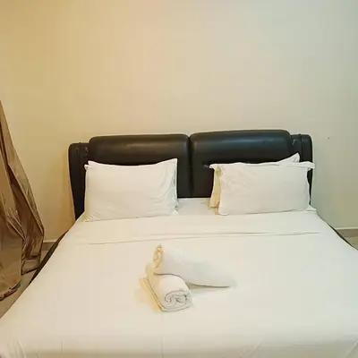 a bed with a towel on top of it at Sunsega Hotel in Perai