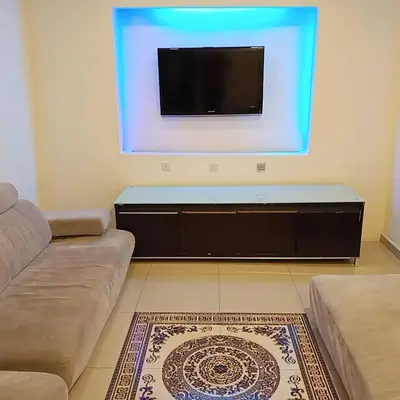 a living room with a couch and a flat screen tv at Sunsega Hotel in Perai