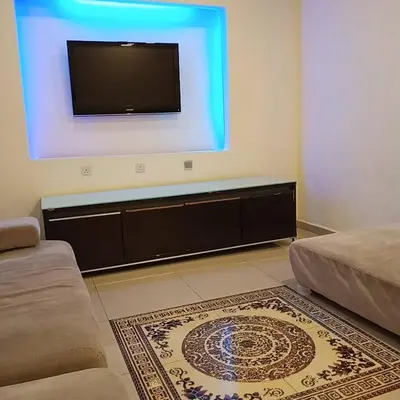 a living room with a flat screen tv on a wall at Sunsega Hotel in Perai