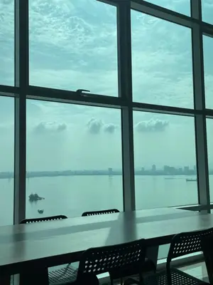 a table and chairs in front of a large window at Maritime Suite Haus - Penang Top Sea View in Jelutong