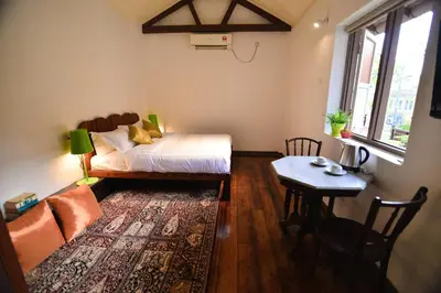 a small room with a bed and a table at Sarang Paloh Heritage Stay in Ipoh