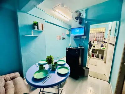 a blue kitchen with a table and a refrigerator at Apartment in gelugor usm in Gelugor