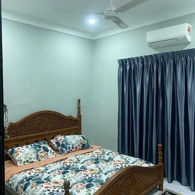 a bedroom with a bed and a blue curtain at Darainhomestay in Gua Sai
