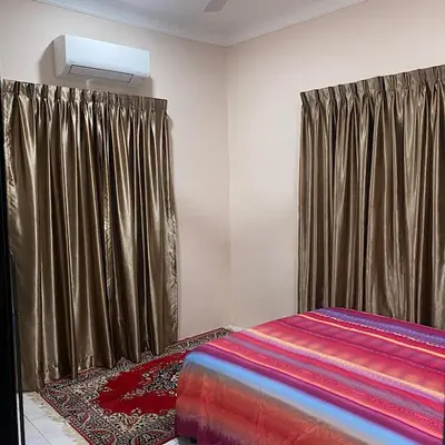 a bedroom with a bed with curtains and a rug at Darainhomestay in Gua Sai