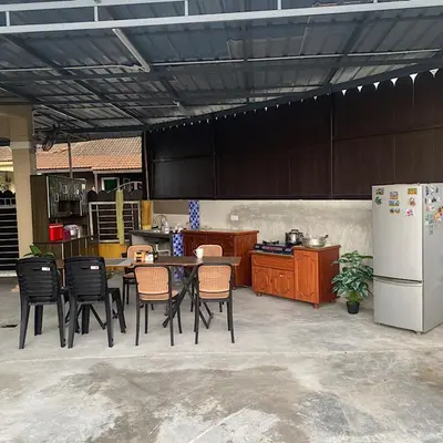 a kitchen with a table and chairs and a refrigerator at Darainhomestay in Gua Sai