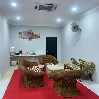 a living room with wicker chairs and a table at Darainhomestay in Gua Sai