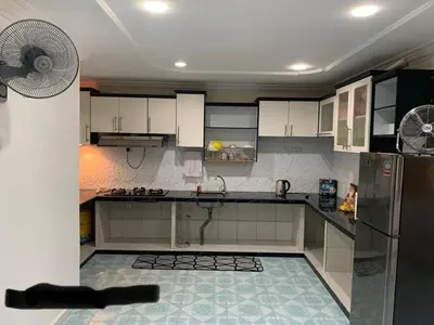 a kitchen with a refrigerator and a fan at Thind place in Kamunting