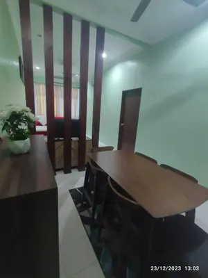a dining room with a wooden table and chairs at Zara's Homestay in Kuala Kurau