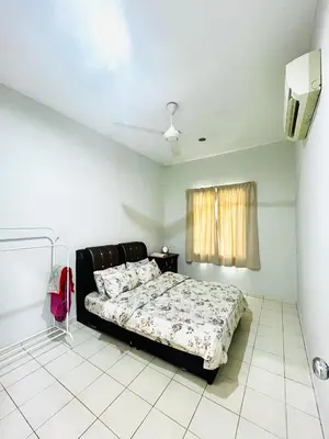 a bedroom with a bed and a tv in it at Teha Homestay Botani in Ipoh