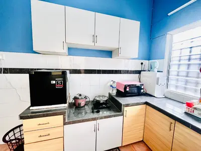 a kitchen with white cabinets and blue walls at Teha Homestay Botani in Ipoh