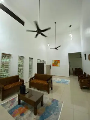 a living room with couches and a ceiling fan at Laman Moon Homestay, Melaka in Gua Sai