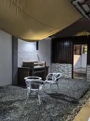 two chairs sitting in a room with a piano at Laman Moon Homestay, Melaka in Gua Sai
