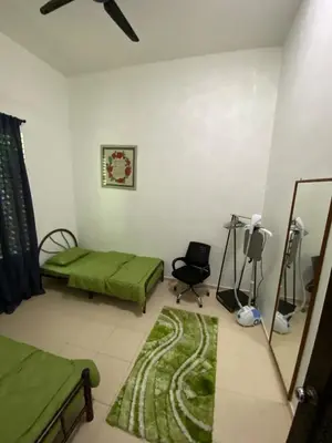 a bedroom with a green bed and a mirror at Laman Moon Homestay, Melaka in Gua Sai