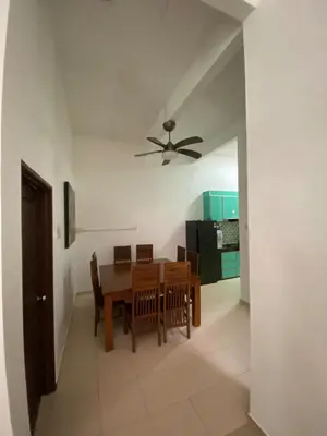 a dining room with a table and a ceiling fan at Laman Moon Homestay, Melaka in Gua Sai