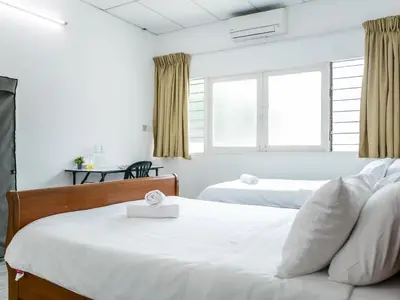 a bedroom with two beds and a window at Lodge 22, 5 min walk to Adventist & Pulau Tikus Market in George Town