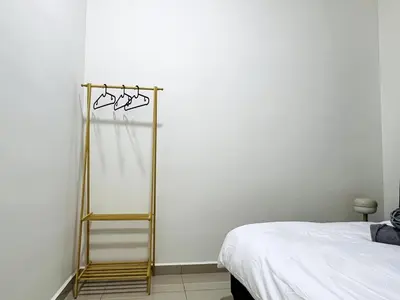 a bedroom with a towel rack next to a bed at SunshineResidence 5pax Near Georgetown in Ayer Itam