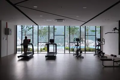a gym with several people exercising on tread machines at SunshineResidence 5pax Near Georgetown in Ayer Itam