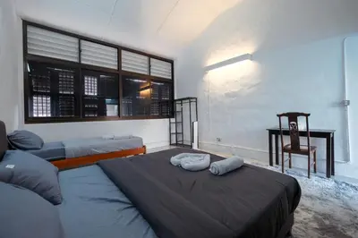 a bedroom with two beds and a chair and a desk at Hutton Haven by MyStay in George Town