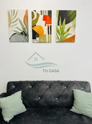 a couch with three pictures on the wall above it at Venus Suite in Setia Alam 2 in Gua Sai