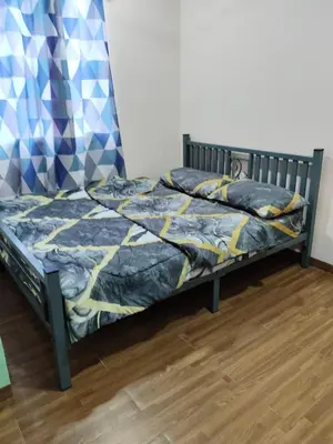 a bed with a blue and yellow comforter in a room at Homestay Teratak D'Desa in Gua Sai
