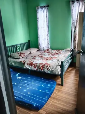 a bedroom with a bed and a blue wall at Homestay Teratak D'Desa in Gua Sai