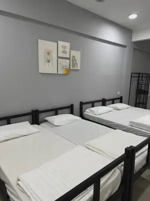 three beds in a room with white walls at Modern & Cozy Home Stay in Kampar