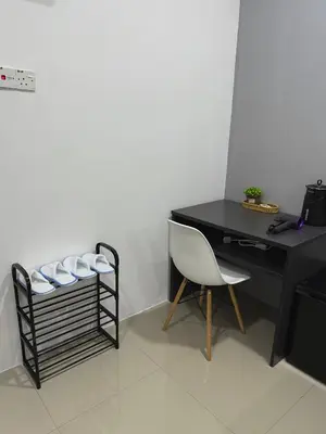 a black desk with a white chair and a table at Modern & Cozy Home Stay in Kampar
