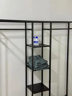 a black shelf with two bottles and towels on it at Modern & Cozy Home Stay in Kampar