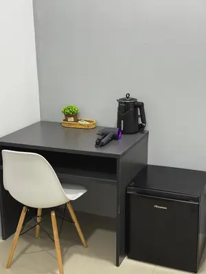 a black desk with a white chair and a coffee maker at Modern & Cozy Home Stay in Kampar
