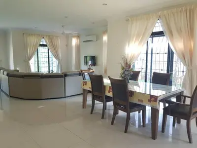 a dining room with a table and chairs and a couch at Kulim LakeView Homestay for Msliims Only in Kulim