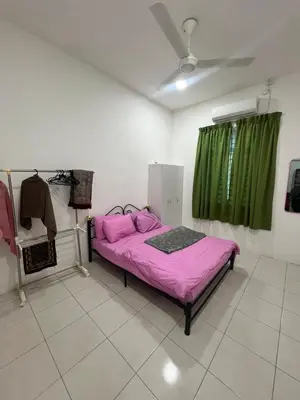 a bedroom with a pink bed and a green curtain at Villa Umar Home Stay in Gua Sai