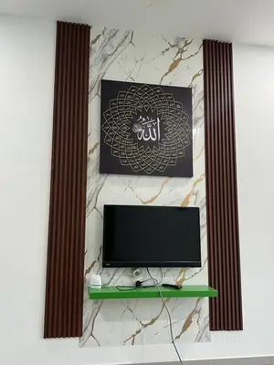 a television on a wall with a marble wall at Villa Umar Home Stay in Gua Sai