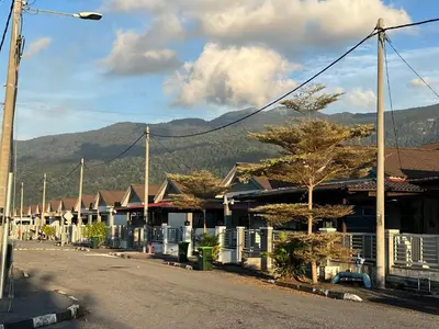 a row of houses on a street with mountains in the background at Villa Umar Home Stay in Gua Sai