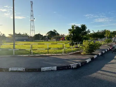 a road with a fence and a field with a tower at Villa Umar Home Stay in Gua Sai