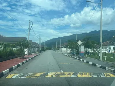 an empty street with mountains in the background at Villa Umar Home Stay in Gua Sai