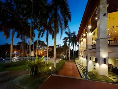 a night view of a building with palm trees at DamaiNest in Lumut