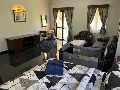 a living room with a bed and a desk at DamaiNest in Lumut