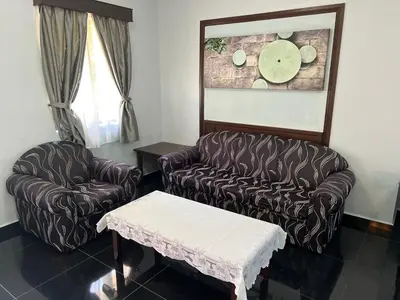 a living room with two chairs and a coffee table at DamaiNest in Lumut