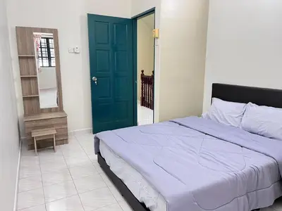 a bedroom with a bed and a blue door at Menglembu Hill Home Stay in Ipoh