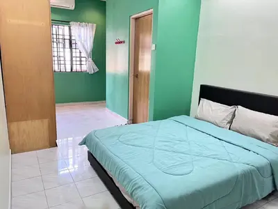 a bedroom with a bed in a room with green walls at Menglembu Hill Home Stay in Ipoh